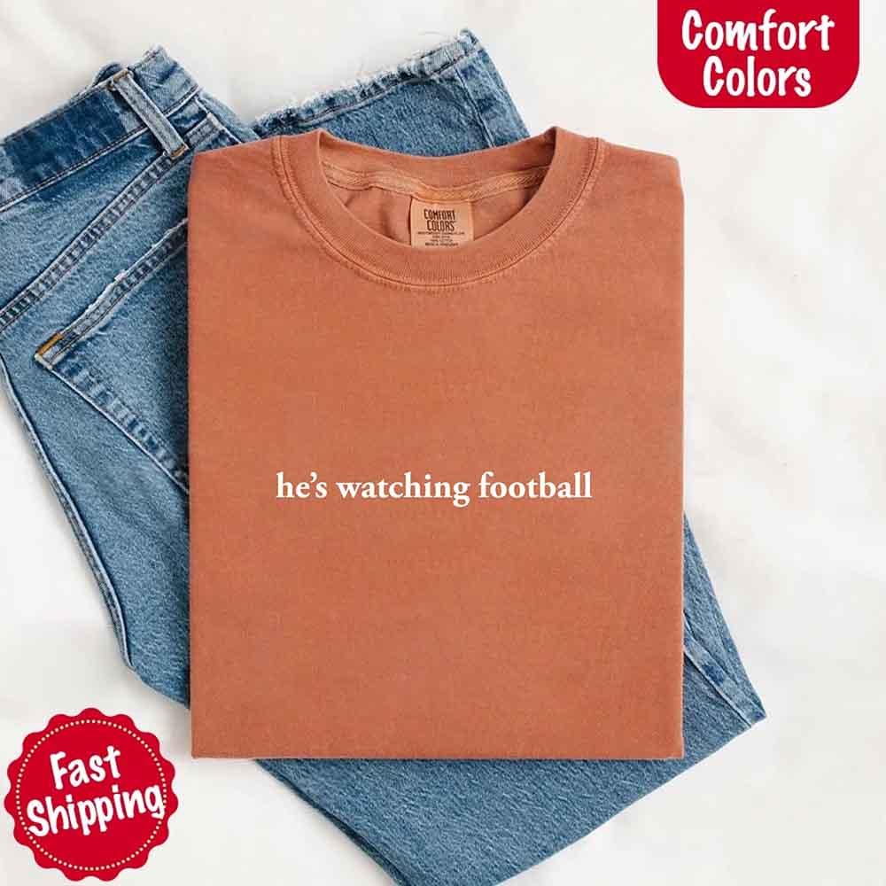 He’s Watching Football Tee - Comfort Colors Funny Shirt for Her