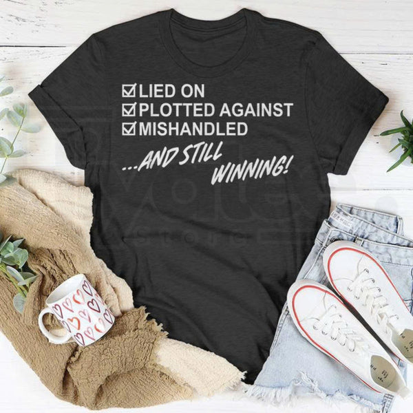 "Lied On, Plotted Against, Still Winning" Unisex T-Shirt – Resilience Graphic Tee